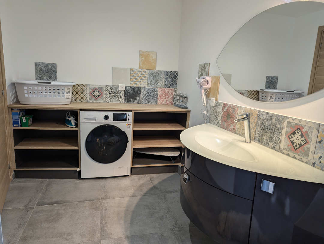 Salle de bain du rez de chaussée avec vue sur la machine à laver et lavabo