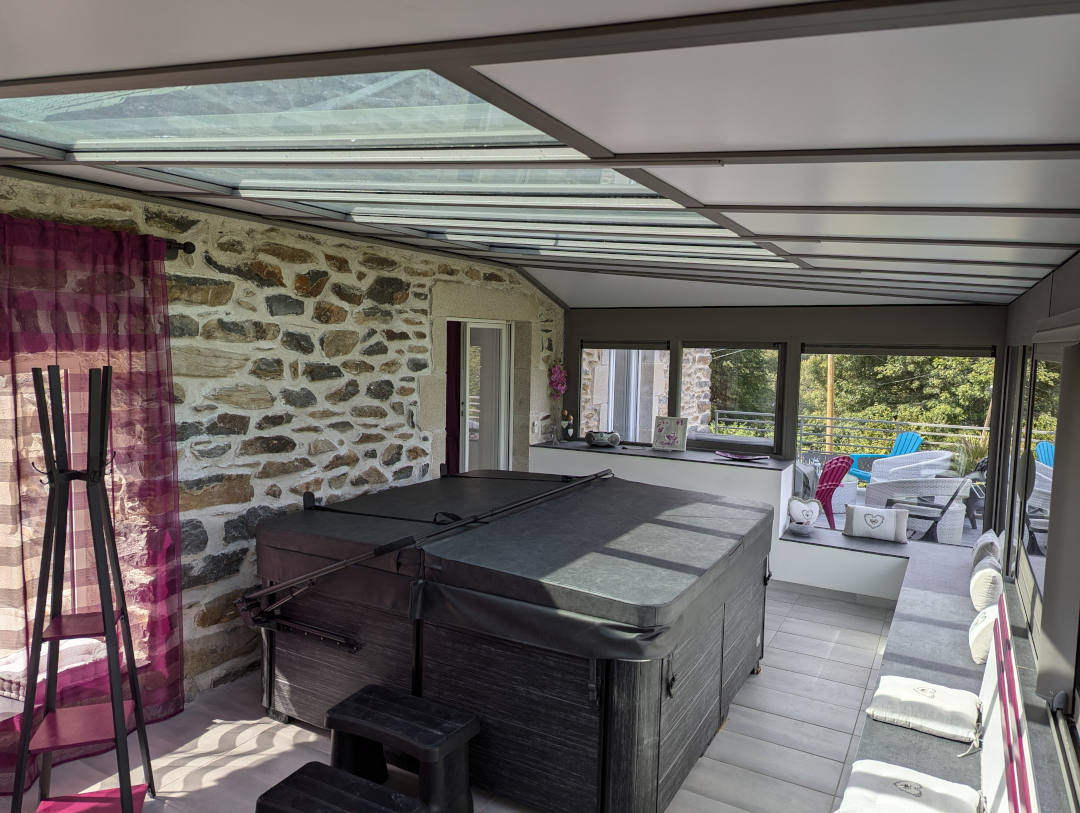 Jacuzzi fermé et terrasse extérieur en fond